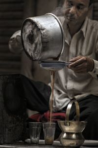 Close-up of man pouring tea in cup