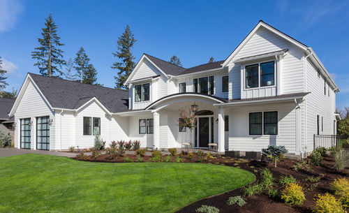 Beautiful modern farmhouse style luxury home exterior with blue sky