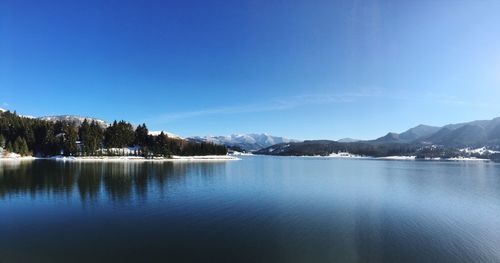 Scenic view of lake and mountains on sunny day