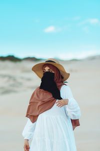 Rear view of woman standing at beach