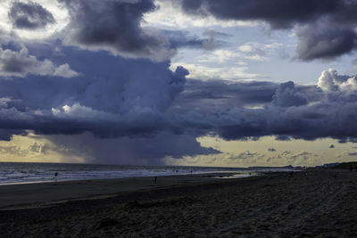 Scenic view of beach against cloudy sky