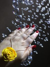 Close-up of woman hand over black background