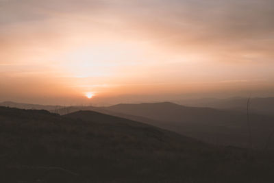 Scenic view of silhouette mountains against sky during sunset