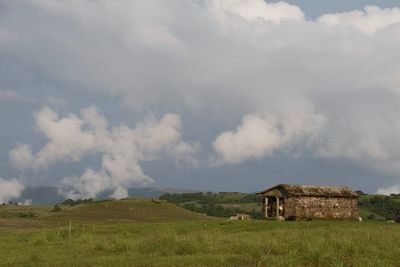 Built structure on field against sky