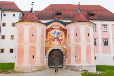 Rear view of man outside temple against building