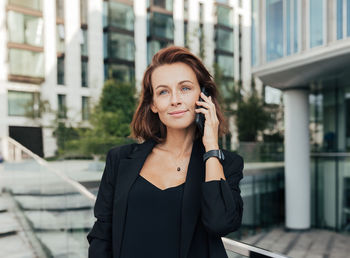 Businesswoman talking on mobile phone in city