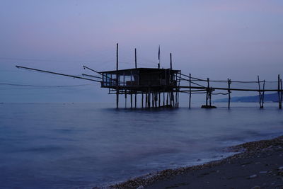 Pier over sea against sky at sunset