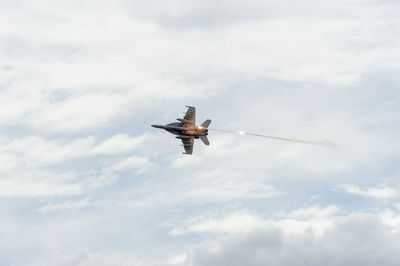 Low angle view of airplane flying against sky