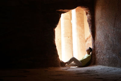 Man looking up while sitting in cave