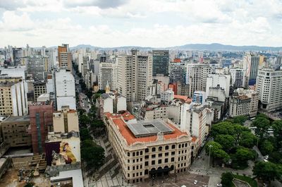 Aerial view of city against cloudy sky