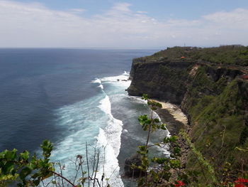 Scenic view of sea and cliff against sky