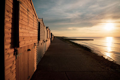 Scenic view of beach huts against sky during sunset