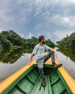 Portrait of woman sitting on boat against sky