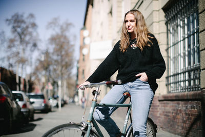 Portrait of young woman riding bicycle in city