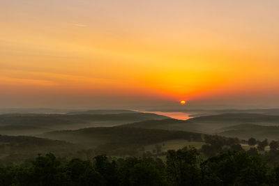 Scenic view of landscape against orange sky