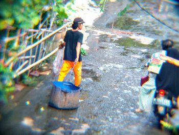 Rear view of men working in forest