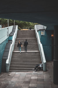 Rear view of people walking on staircase