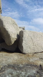Close-up of stones on rock against sky