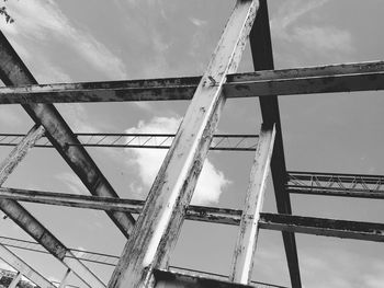 Low angle view of bridge against cloudy sky
