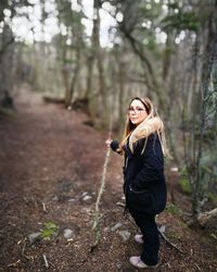 Woman walking on dirt road in forest