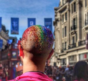 Rear view of man in multi colored city