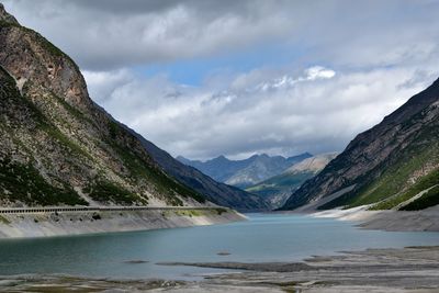 Scenic view of lake by mountains against sky