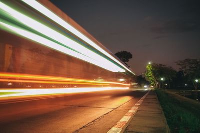 Light trails on road against sky at night