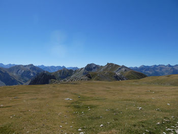 Scenic view of landscape and mountains against clear blue sky