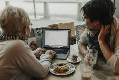 Women using laptop in cafe