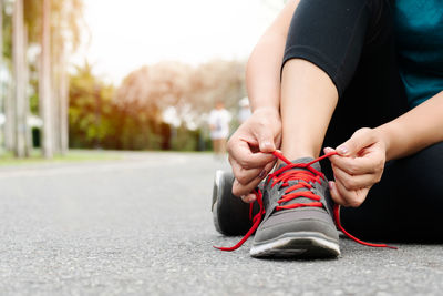 Sport woman tying shoelace before running, outdoor activities