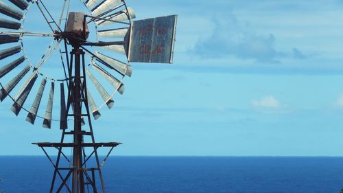 Crane by sea against sky