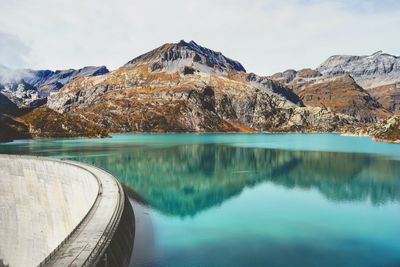 Dam by mountain against sky