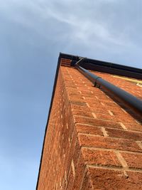 Low angle view of building against sky brickwork house corner gutter down pipe 