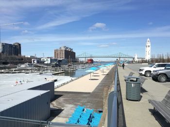 View of swimming pool by buildings in city against sky