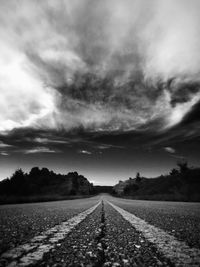 Surface level of road against cloudy sky