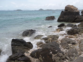 Rocks on sea shore against sky