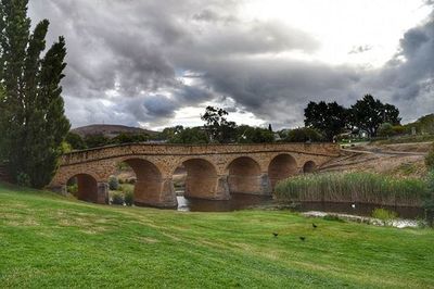 Bridge over river against cloudy sky