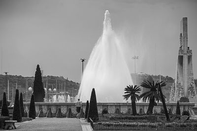 Fountain in city against sky