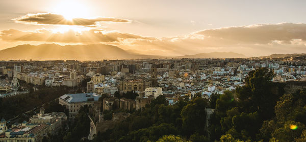 Panoramic shot of cityscape against sky during sunset
