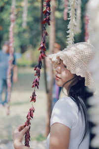 Woman looking flowers hanging outdoors