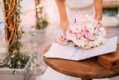 Midsection of woman holding flower bouquet