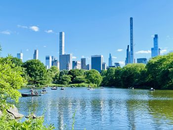 View of the scenic conservatory lake against the new york city skyline. 