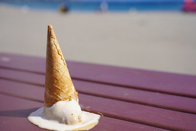 Close-up of ice cream fallen upside-down on bench at beach in tenerife