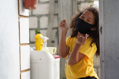 Full length of woman standing against yellow wall