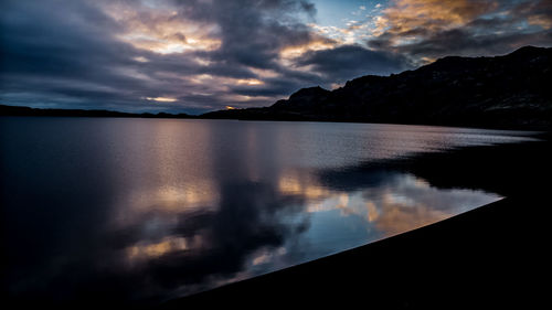 Scenic view of lake against sky at sunset