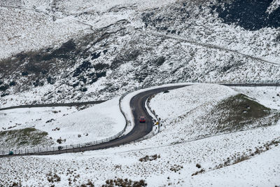 High angle view of car moving on road in snow covered mountain