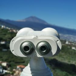 Close-up of coin-operated binoculars against sky