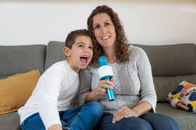 Mother and son singing with microphones at home