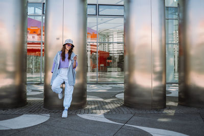 Portrait of young cool woman holding smartphone. sending text messages. isolated on background