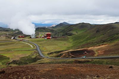 Road by mountain leading towards factory